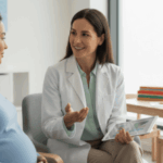 Pregnant woman discussing maternal mental health with a healthcare professional in a calm clinical setting.